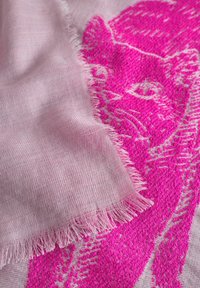 Roze geweven sjaal met een getextureerd kattenontwerp in felroze tegen een lichter roze achtergrond, met rafelige randen langs de rand.