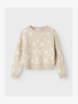 Bež volnen pulover s krajšim krojem. Ima teksturirana bela črke, ki speljujejo "Paris" in "French" v različnih velikostih, z dolgimi rokavi.