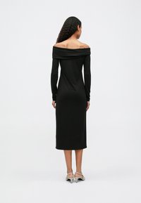 Μαύρο φόρεμα off-the-shoulder με μακριά μανίκια, μήκους μέχρι το μισό της γάμπας, εφαρμοστό σώμα, απαλή υφή υφάσματος και απλό σχέδιο.