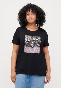 Schwarzes T-Shirt mit kurzen Ärmeln, das ein grafisches Design aus Tierprints und einer Herzform in verschiedenen Brauntönen und Rosatönen zeigt.