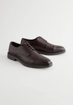 Bruine leren nette schoenen met een gladde textuur, vetersluiting, ronde neus en contrasterende zwarte zool. Minimalistisch ontwerp met stikaccenten.