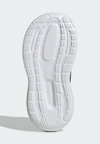 Valge tennisejalatsi tald, millel on tekstureeritud kumm pinnal soonte ja harjaste mustriga, märgistatud "CLOUDFOAM" pehmendava toe jaoks.