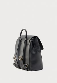 Mochila de cuero negro con forma estructurada, asa superior, correas ajustables, herrajes dorados y acabado texturizado.