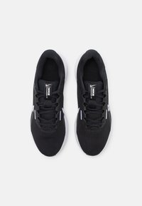 Schwarze Sport-Sneaker mit einer strukturierten oberen Fläche, Mesh-Details und weißen Akzenten auf der Sohle und der Markierung. Schnürdesign und gepolsterter Innenraum.