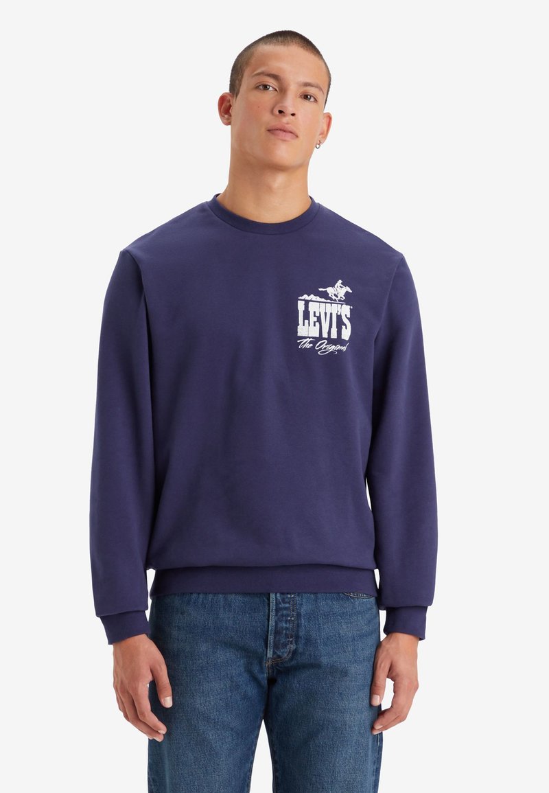 Marineblauwe sweatshirt met een ronde hals, voorzien van een grafisch logo op de voorkant en elastische boorden. Gemaakt van zacht katoen. Casual fit.