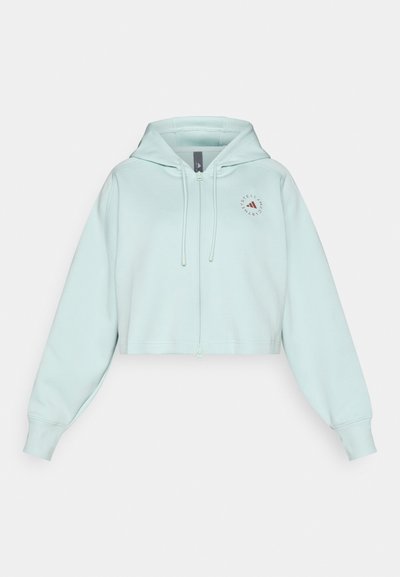 Κοντοκομμένο φούτερ με φερμουάρ σε ανοιχτό μέντα, από βαμβακερό μείγμα, με κουκούλα με κορδόνι και μικρή κυκλική λεπτομέρεια λογότυπου στο αριστερό μέρος του στήθους.
