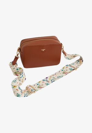 Bruine leren crossbodytas met gouden ritssluiting en een brede witte band versierd met kleurrijke bloemenpatronen.