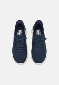 Marinefarbene Netz-Athletikschuhe mit weißen Sohlen, abgerundetem Zeh, Schnürsenkeln und weichem Textilmaterial für Atmungsaktivität.