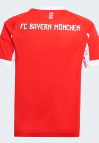 Rød fotballtrøye med hvite detaljer, med "FC BAYERN MÜNCHEN" trykt på ryggen i hvitt. Laget av glatt, lett stoff.