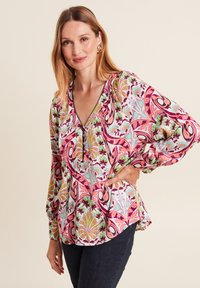 Bunte Bluse mit floralem Muster in Pink, Grün und Blau, mit tiefem V-Ausschnitt und langen Ärmeln. Texturierter Stoff und lockere Passform.