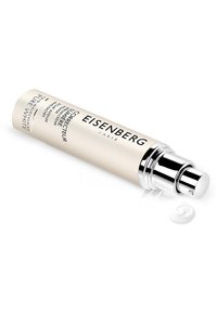 Correcteur de peau Eisenberg Paris dans un tube cylindrique beigne avec des accents argentés ; comprend un distributeur par pompe. Un petit tourbillon de crème blanche est visible.