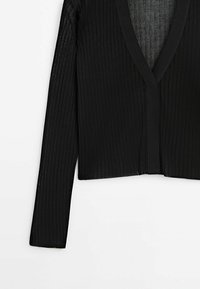 Schwarz gerippte Strickjacke mit langen Ärmeln und V-Ausschnitt. Sie bietet einen strukturierten Stoff und eine cropped Länge mit offenem Frontbereich und ohne Verschlüsse.