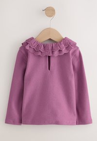 Top morado de manga larga con cuello con volantes y una abertura en forma de ojo de cerradura en la espalda. Hecho de tela suave con una textura lisa.