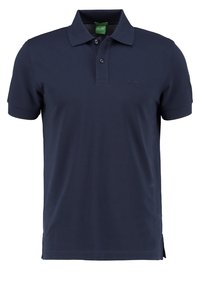 Polo bleu marine en coton lisse. Doté d'un col classique, d'une patte à deux boutons et de détails métallisés subtils sur la poitrine.