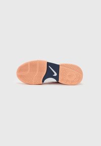 Sportsskoens sål i orange og marineblå. Har et fiskebensmønster for godt greb, med et rundt logo og perforerede detaljer.