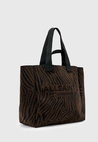 Hnědá a černá zebra pruhovaná taška přes rameno s černými textilními uchy a potiskem "ALLSAINTS LONDON" na přední straně. Měkká textura.
