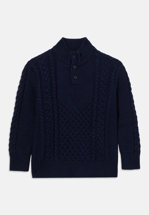 Pull en maille torsadée bleu marine avec col montant côtelé et trois boutons noirs sur la patte de devant, manches longues et motifs texturés.