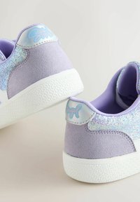 Pair of lavender sneakers with glittery side panels, white textured soles, and holographic heel tabs featuring pastel pink text.