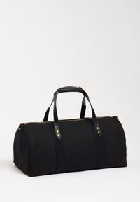 Černá plátěná taška přes rameno se zlatým zipem, černými koženými rukojeťmi a zlatým kováním. Má zaoblený tvar a detail švu na předním panelu.