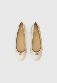 Bézs balettcipő finom mintázatú logóval, kerek orral és sima elejével, aranyszínű díszítéssel.