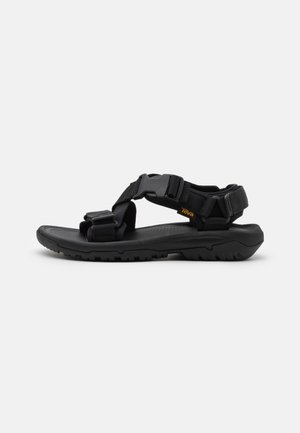 Black outdoor sandal with adjustable nylon straps, a contoured sole, and textured footbed. Features a durable rubber outsole for traction.