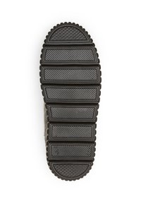 Semelle de chaussure en caoutchouc noir avec des motifs texturés horizontaux et verticaux, un design segmenté aux bords arrondis et un talon légèrement surélevé.