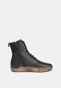 Bota de cuero negro hasta el tobillo con puntera redonda, cordones en la parte delantera, cremallera lateral y suela de goma marrón texturizada. Presenta ojales de metal plateado y detalles de costura.