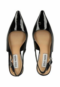 Tacones slingback de charol negro con puntas afiladas, lados abiertos y una hebilla ajustable de plata. Textura suave y brillante en toda la superficie.