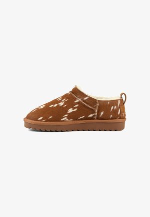 Brun slip-on sko med hvidt plettet mønster, snøredetalje, trække-flig ved hælen og tyk, rillede sål, foret med blød cremefarvet pels.