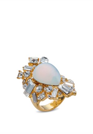 Gouden ring met een centraal peervormige opaalachtige steen, omringd door verschillende heldere kristalvormen en ingewikkeld detailwerk.