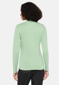 Hellgrünes Langarmtop aus weichem Stoff, mit taillierter Passform und Rundhalsausschnitt, glatter Oberfläche und subtiler Elastizität.