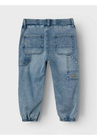 Pantaloni jogger in denim blu con vita e polsini elastici, dotati di due tasche posteriori e una tasca laterale con etichetta decorativa.