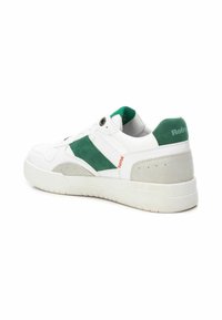 Zapatillas blancas con detalles en ante verde, detalles grises, suela de goma y un collar acolchado con un logo en el talón.