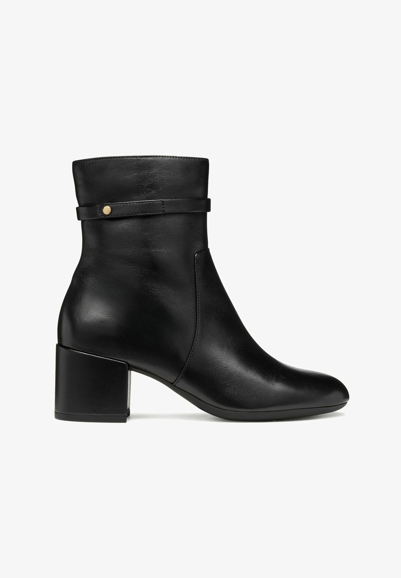 Bottines noires en cuir lisse, avec un talon bloc, un design minimaliste et une sangle décorative agrémentée d'un bouton doré.