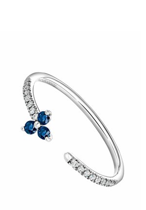 Brazalete abierto plateado con una fila de pequeñas piedras transparentes en cada extremo y tres piedras preciosas azules agrupadas cerca de un extremo.