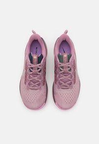 Buty do biegania Nike w jasnoróżowym i fioletowym kolorze, z teksturowaną siateczką, sznurowadłami, wzmocnionymi oczkami oraz elastyczną podeszwą.
