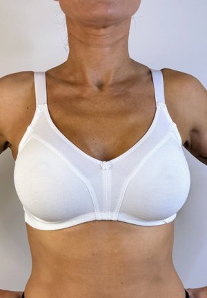 Sostén de algodón blanco con tirantes ajustables, copas sin costuras y un acento floral decorativo entre ellas. Presenta una textura suave y elástica.