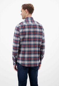 Bageste udsigt af en herre flannel skjorte med et ternet mønster i marineblå, rød og hvid. Lange ærmer med knaplukning ved manchetterne. Casual kravedesign.