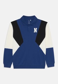 Blå polo skjorte med lange ærmer, har kontrasterende sorte og hvite vinklede fargeblokker, tre-knapps placket og en hvit "N" logo.