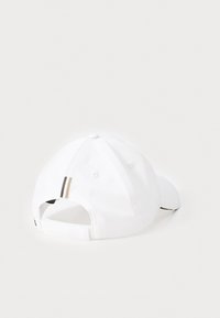 White cap with a structured shape, featuring a solid color, ventilation holes, and a contrasting stripe detail at the back.