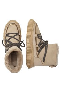 Botines beige con exterior de ante, suela de goma texturizada, cordones grises y cuello forrado de pelo. Acentos dorados en el lateral y en la punta.