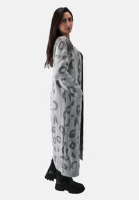 Grå lang cardigan med leopardmønster, med åben front, ribbede manchetter og sidelommer, lavet af blødt strikket stof.