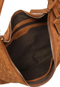 Helle Wildleder-Handtasche mit gewebtem Design, ausgestattet mit einer Reißverschlusstasche und einem innen mit Stoff ausgekleideten Innenraum. Sichtbare silberne Beschläge.