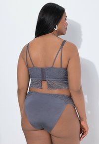 Reggiseno grigio con schienale in pizzo e mutandine abbinate, caratterizzati da un delicato bordo in pizzo, spalline regolabili e una finitura in satin liscia.