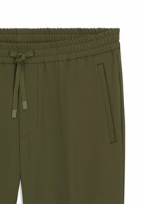 Olivgrüne Sporthose mit einem elastischen Bund und Kordelzug, Seitentasche und glattem, strukturiertem Stoff.