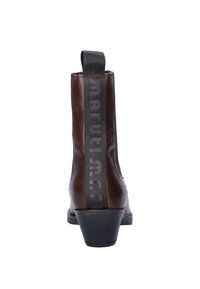Bruine leren enkelboots met een gestapelde hak, voorzien van een zwart elastisch paneel met reliëfletters aan de achterkant.