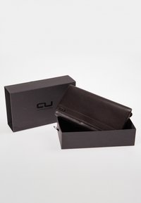 Dark brown leather wallet with a smooth texture, placed inside a black rectangular box featuring the logo "aunts & uncles."