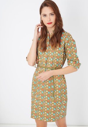 Vestido marrón con un patrón floral en azul, rojo y verde. Presenta mangas cortas, un cuello y un cinturón de tela en la cintura.