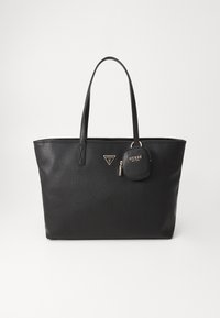 Svart syntetisk totebag med glatt tekstur, to lange håndtak og en liten avtakbar charm med logoaccent. Elegant og romslig design.