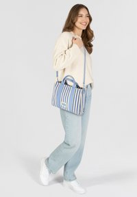 Gestreepte handtas in blauw en room, rechthoekige vorm, met dubbele handgrepen bovenaan en een afneembare schouderriem. Gemaakt van textuursynthetisch materiaal.